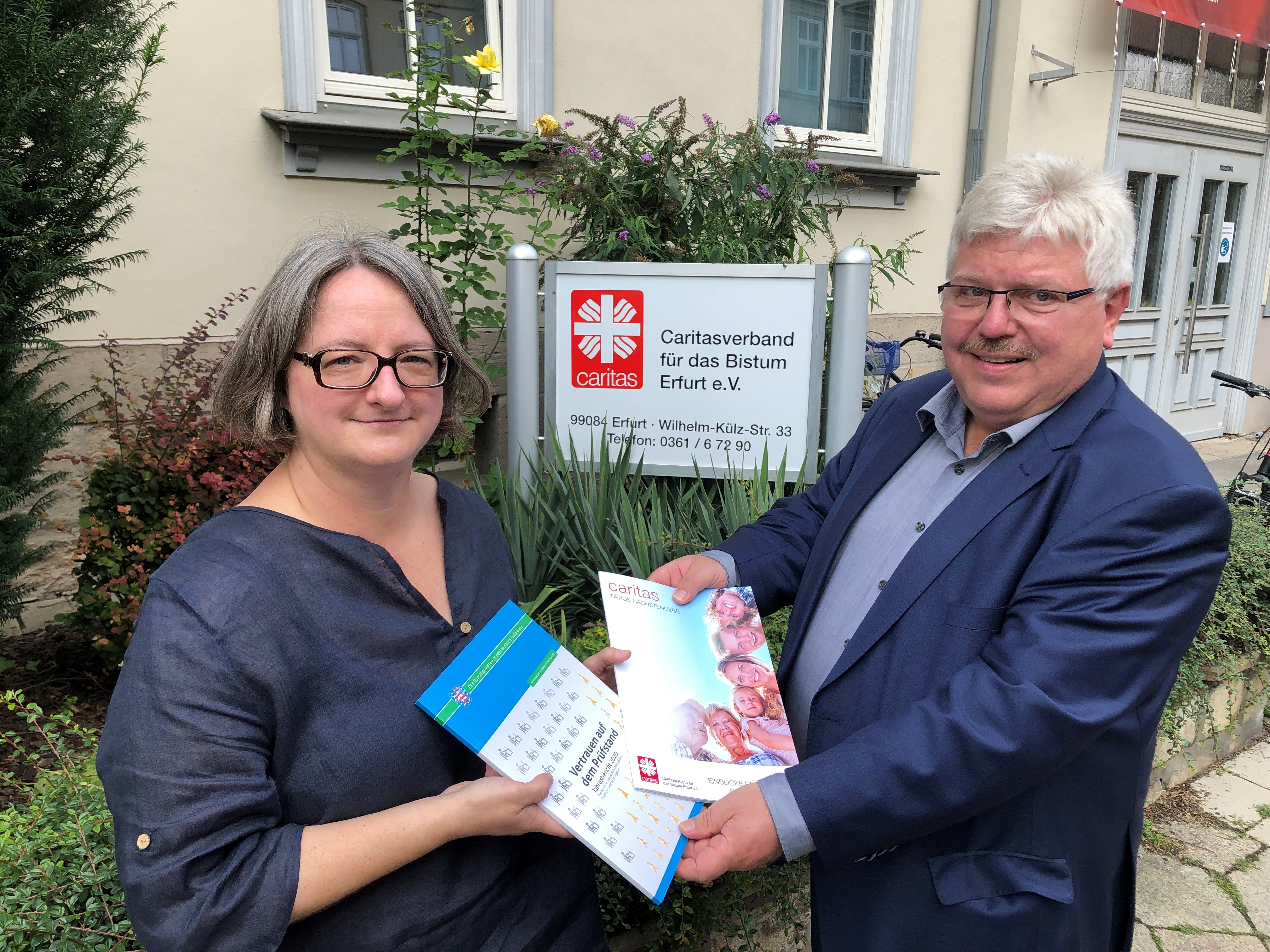 Frau Monika Funk und Dr. Kurt Herzberg tauschen ihre Jahresberichte aus